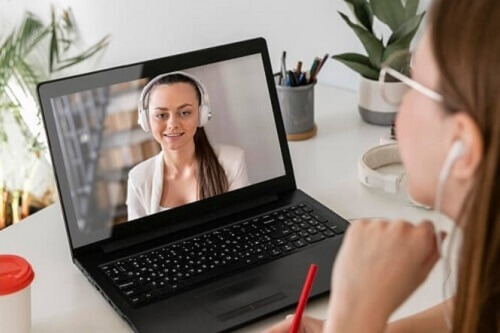 Woman sitting on her laptop, talking with her psychiatric mental health provider.